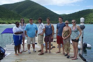 Paul Sikkel’s research team in 2010 on the dock of the Virgin Islands Environmental Resource Station in St. John. Lameshur Bay, where Gnathia marleyi was discovered, is in the background. Sikkel is the bearded man in the middle; Sikkel’s co author and collaborator, Nico Smit, is to his right.