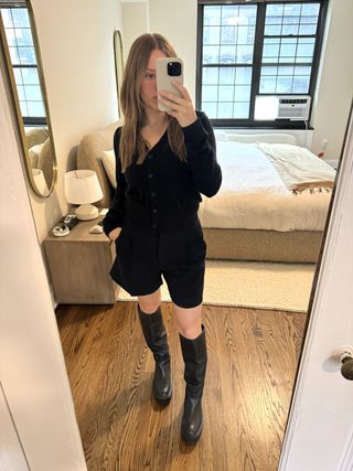 Nikki Chwatt wears Aritzia effortless shorts mid thigh with a black cardigan and black lug-sole knee high boots.