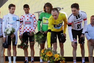 Chris Froome offers flowers to honour the victims of the Nice attack during the stage 13 podium ceremony.
