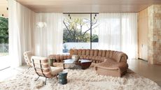 Image of a beige and white living room that has two walls that are windows.