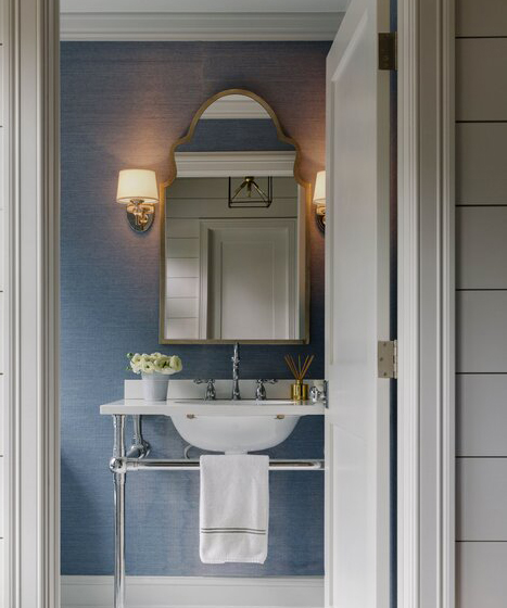 bathroom vanity with blue walls and ornate mirror