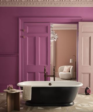 bathroom with pink walls, rolltop bath, double doors