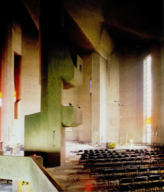Interior view of the Pilgrimage Church. All concrete interior with chairs placed on the floor. To the left, irregular concrete balconies through which light comes in are placed.