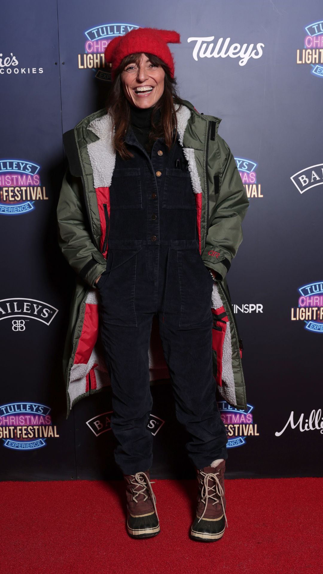 davina mccall wearing a jumpsuit, coat and sorel winter boots