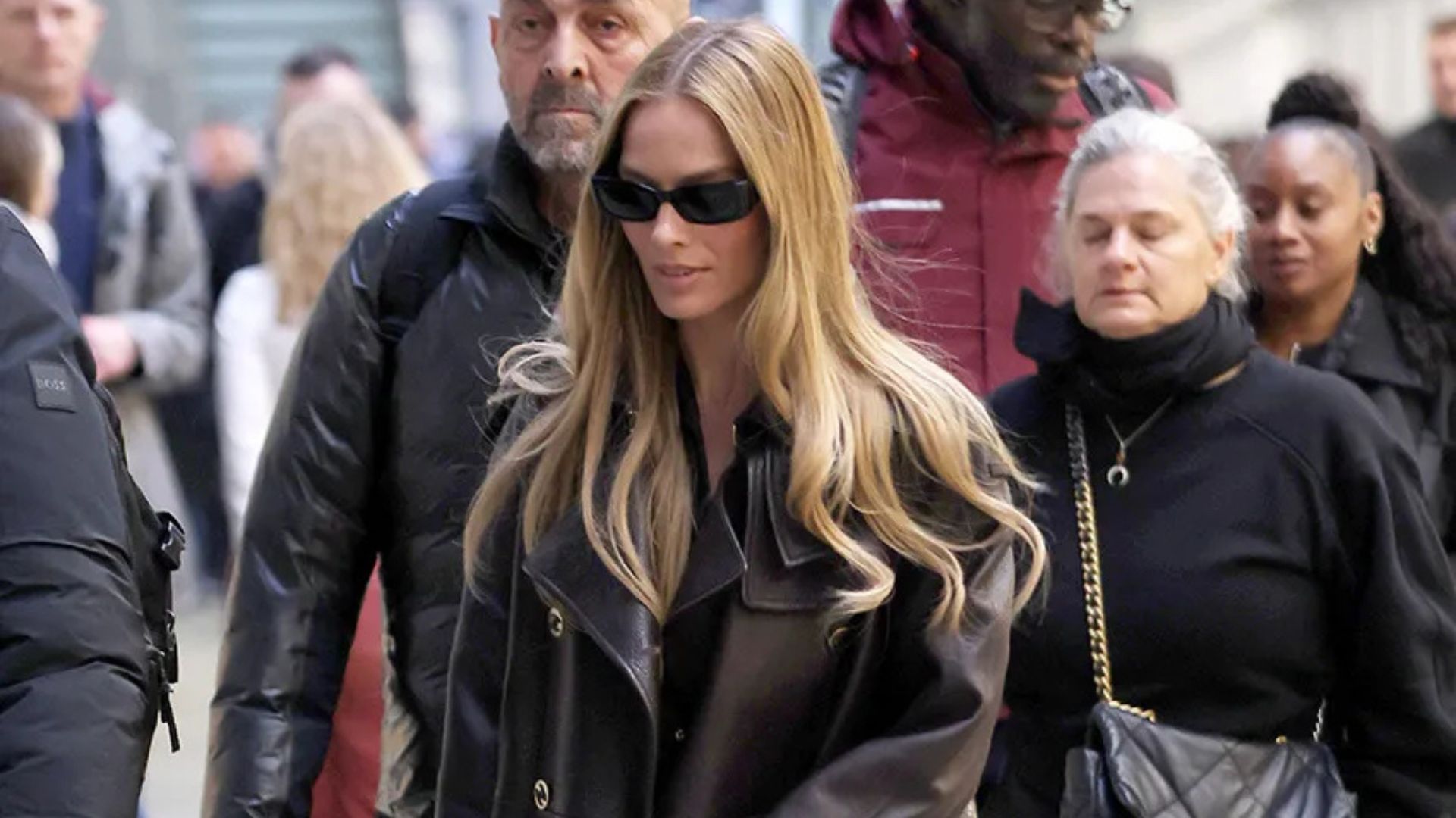 Margot Robbie wearing a Chanel leather trench and track pants at the Eurostar station in Paris