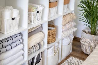 White shelves with folded linen and baskets