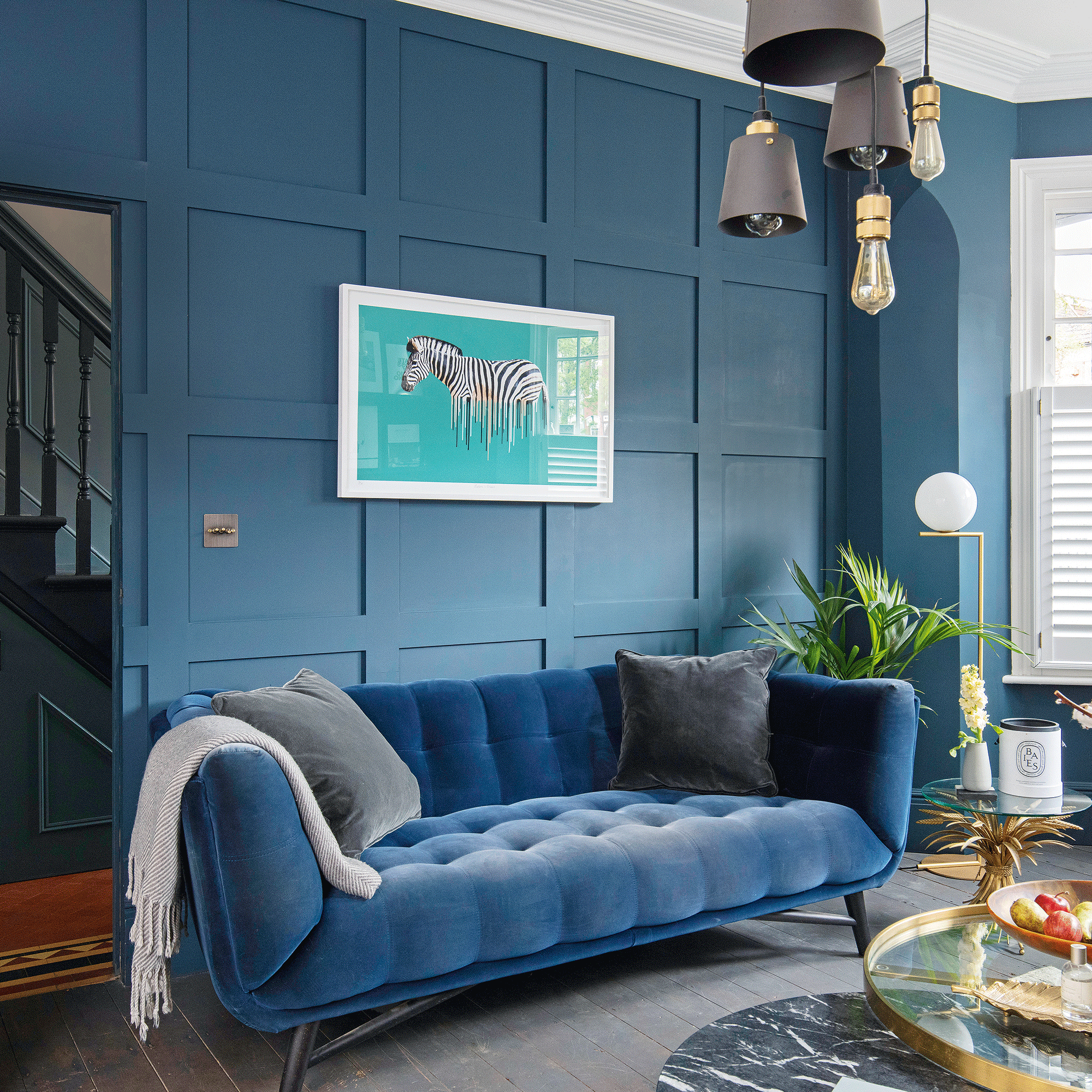 Navy blue velvet sofa in blue living room
