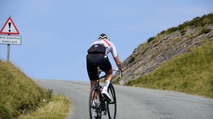 Male cyclist riding up a hill