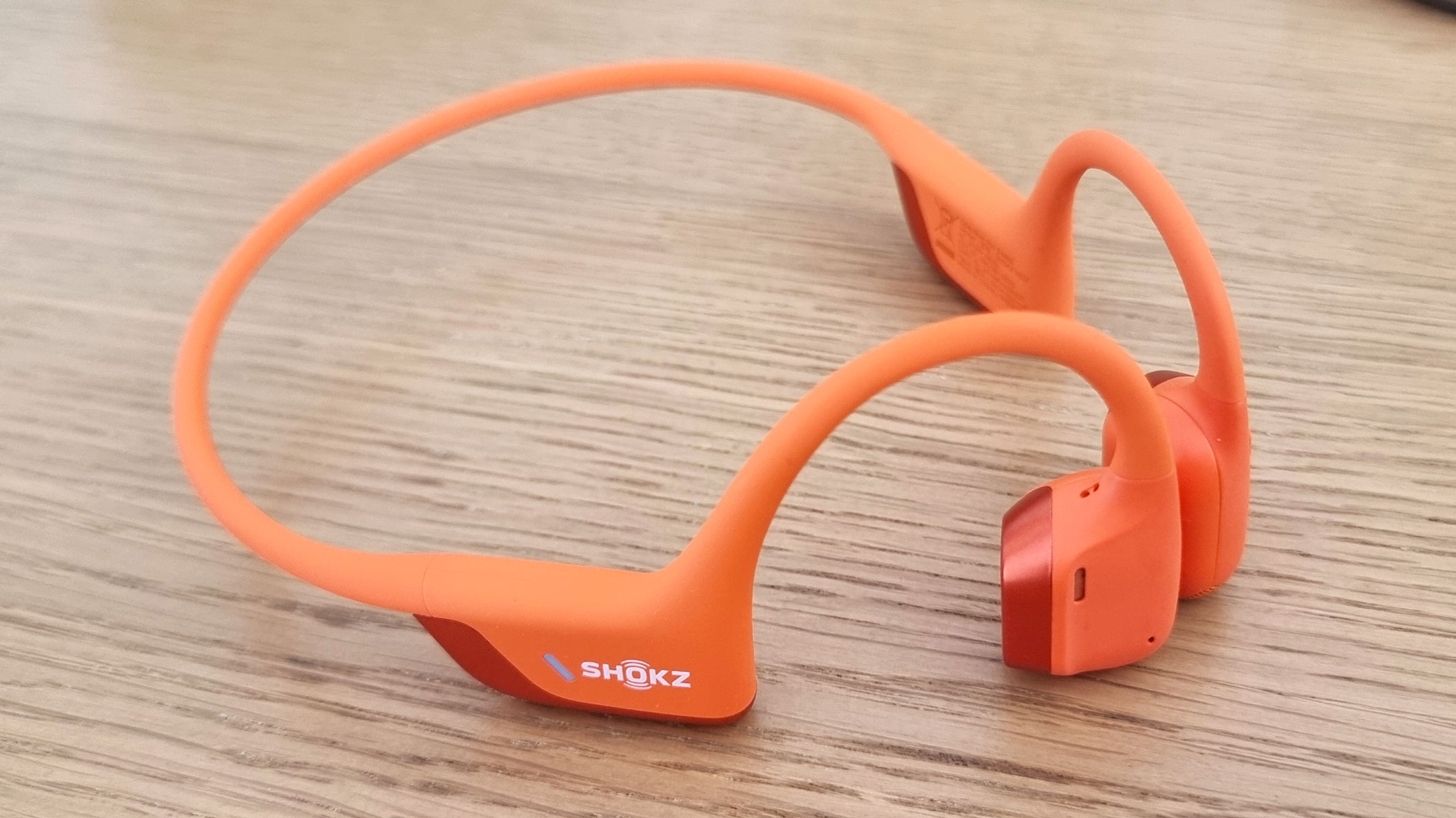 Orange Shokz OpenRun Pro 2 bone conduction headphones, view from the side