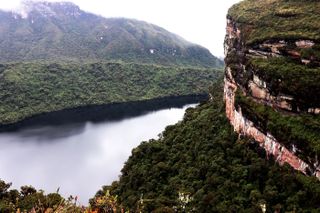 A photo depicting a body of water between two tree-covered mountains in the eastern Peruvian Andes.