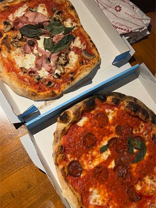 Two pizzas in to-go boxes from Napoli Gang, a delivery pizza chain in Paris.