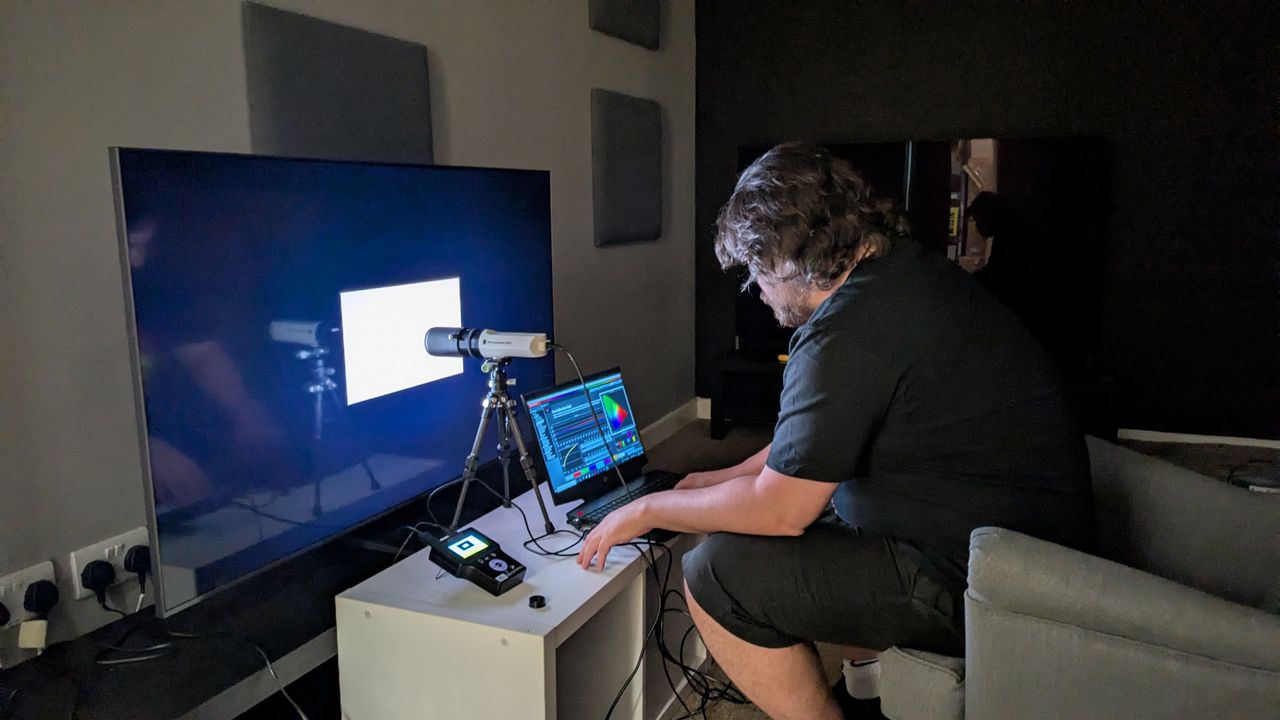 Samsung QN80F being tested with calibration equipment by person