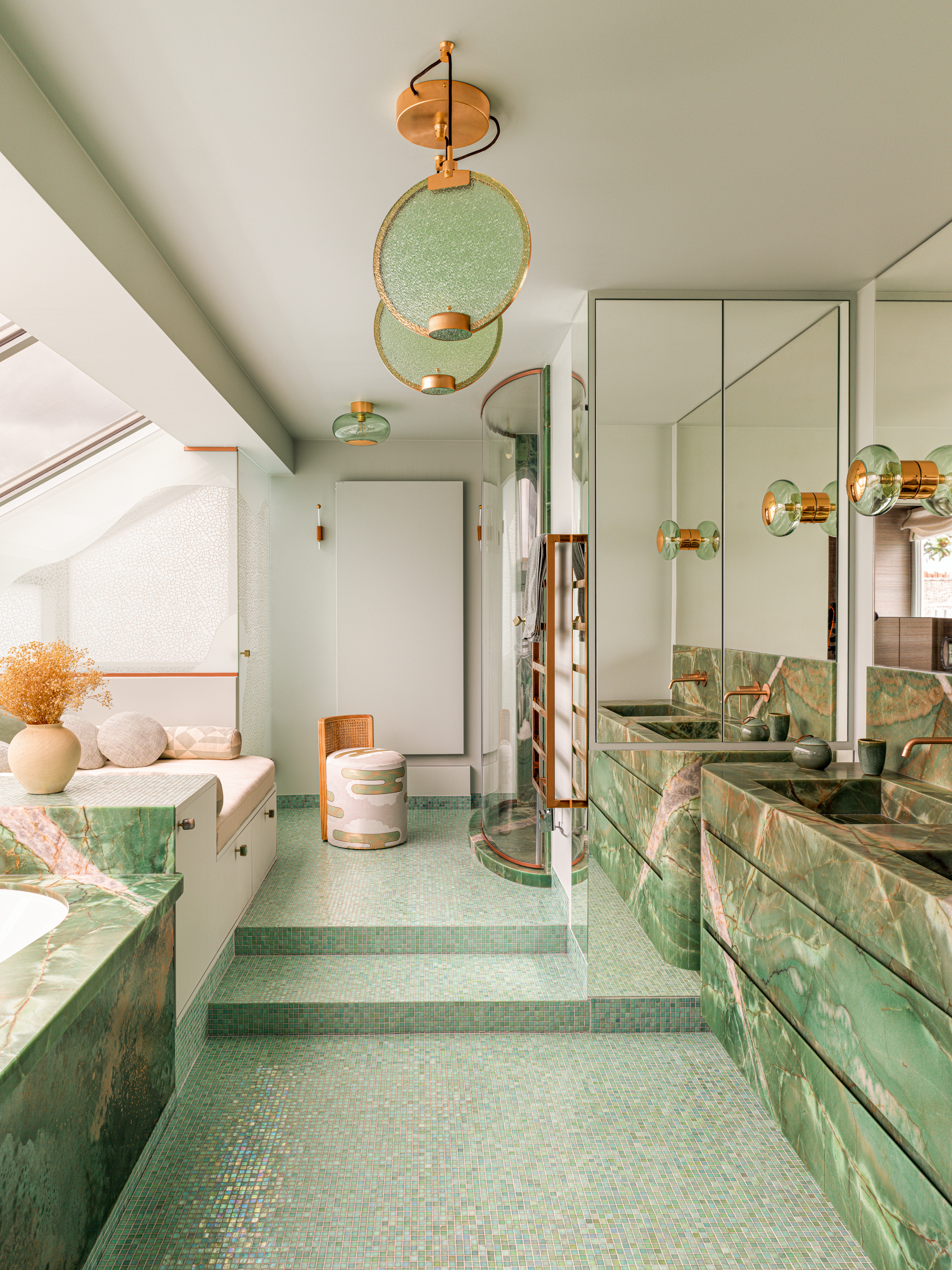 Green bathroom with marble sink and bath, mosaic floor and built-in seating