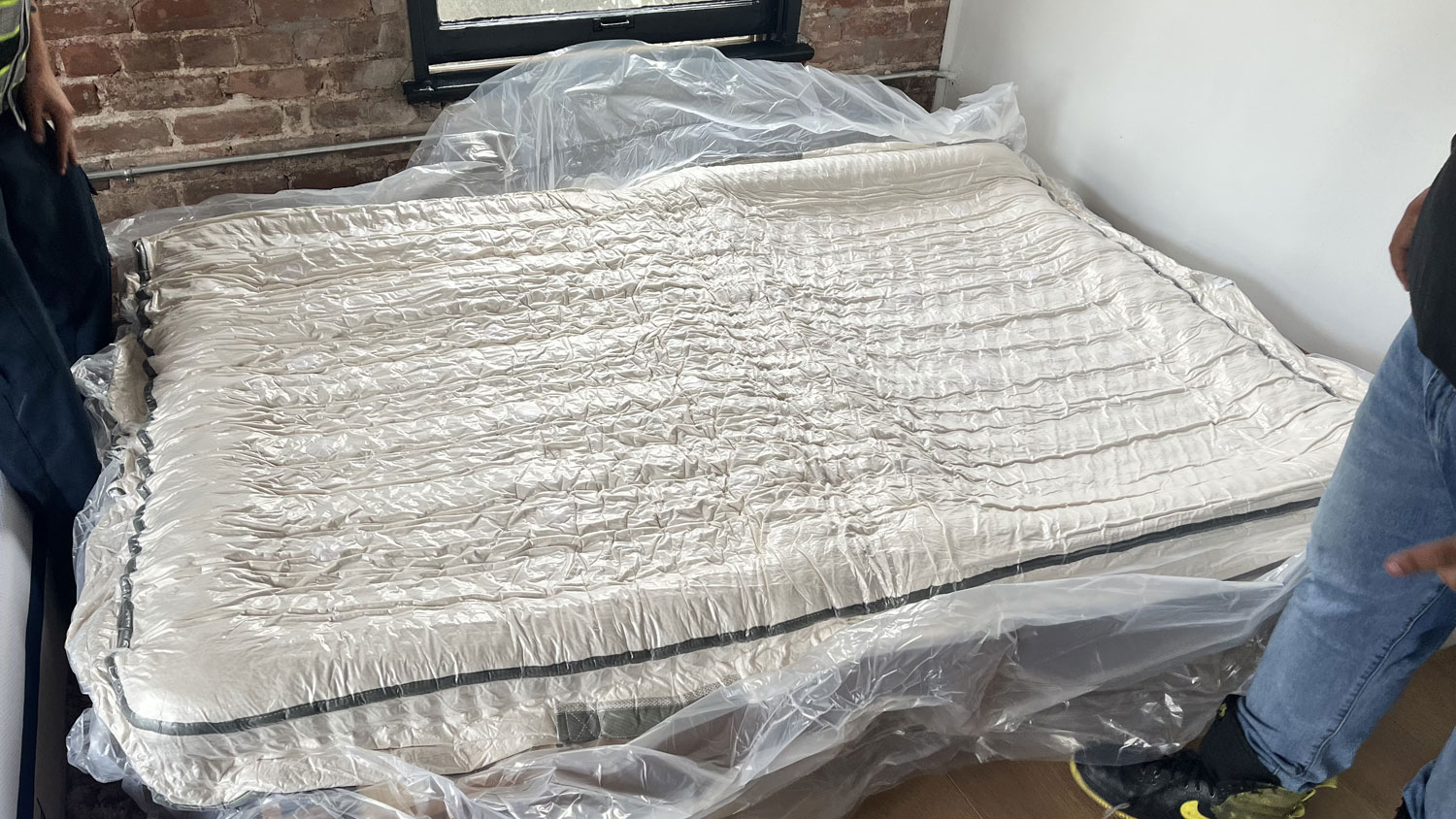 The Avocado Green mattress in its plastic wrapping on a bed