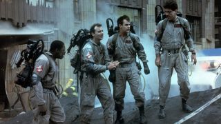 Ernie Hudson, Bill Murray, Dan Aykroyd, and Harold Ramis make a plan in the streets in Ghostbusters.