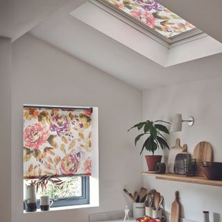 Kitchen with matching floral blinds on window and skylight.