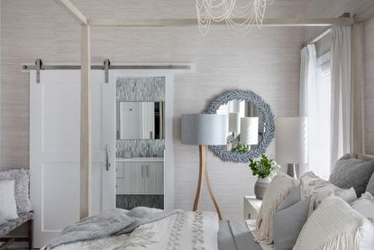 A bedroom with a round mirror adjacent to the bed