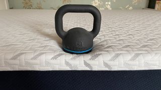 Testing the edge support of the Nectar Classic Memory Foam Mattress with a kettlebell