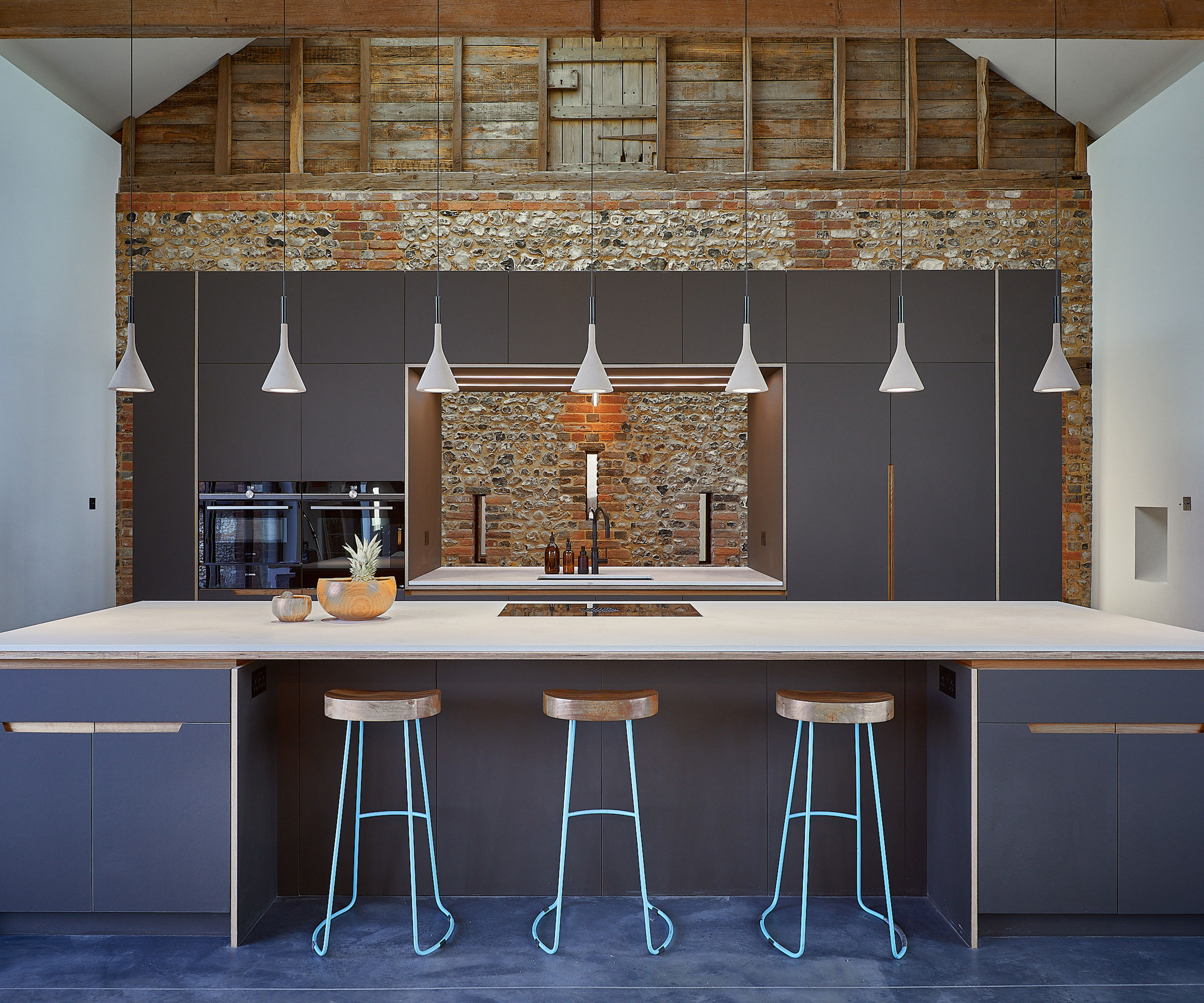 modern grey barn conversion kitchen with exposed brick walls