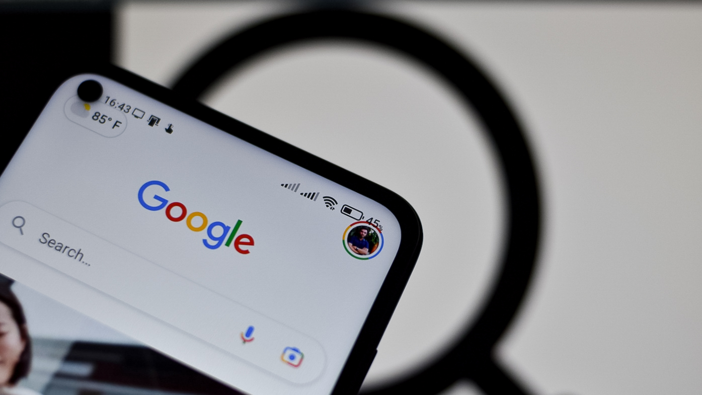 Arka planda büyüteç bulunan Google logosu