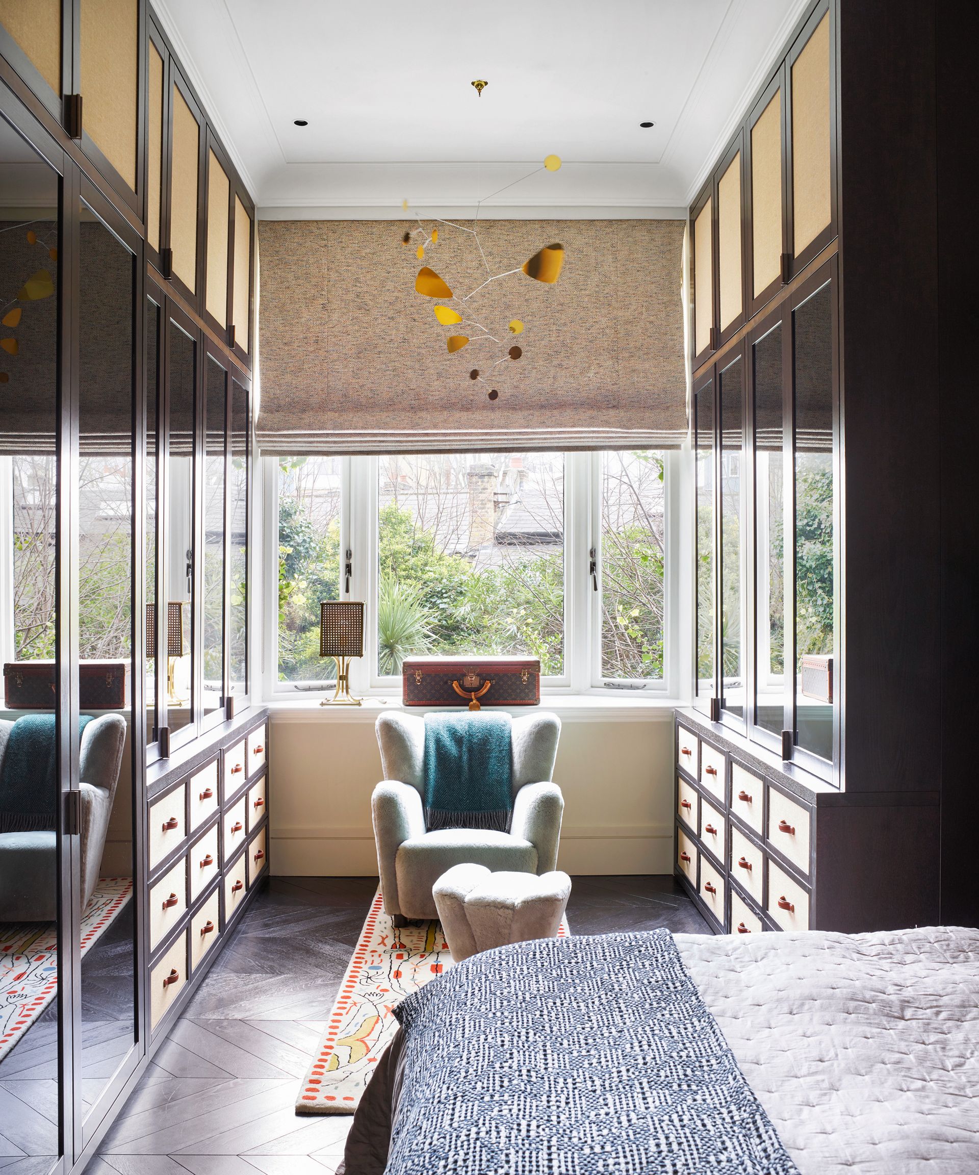 An example of bedroom storage ideas showing a walk-in closet area in a bedroom with double gallery cabinets and drawers