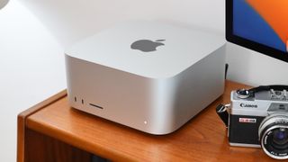 An Apple Mac Studio next to a Canon camera