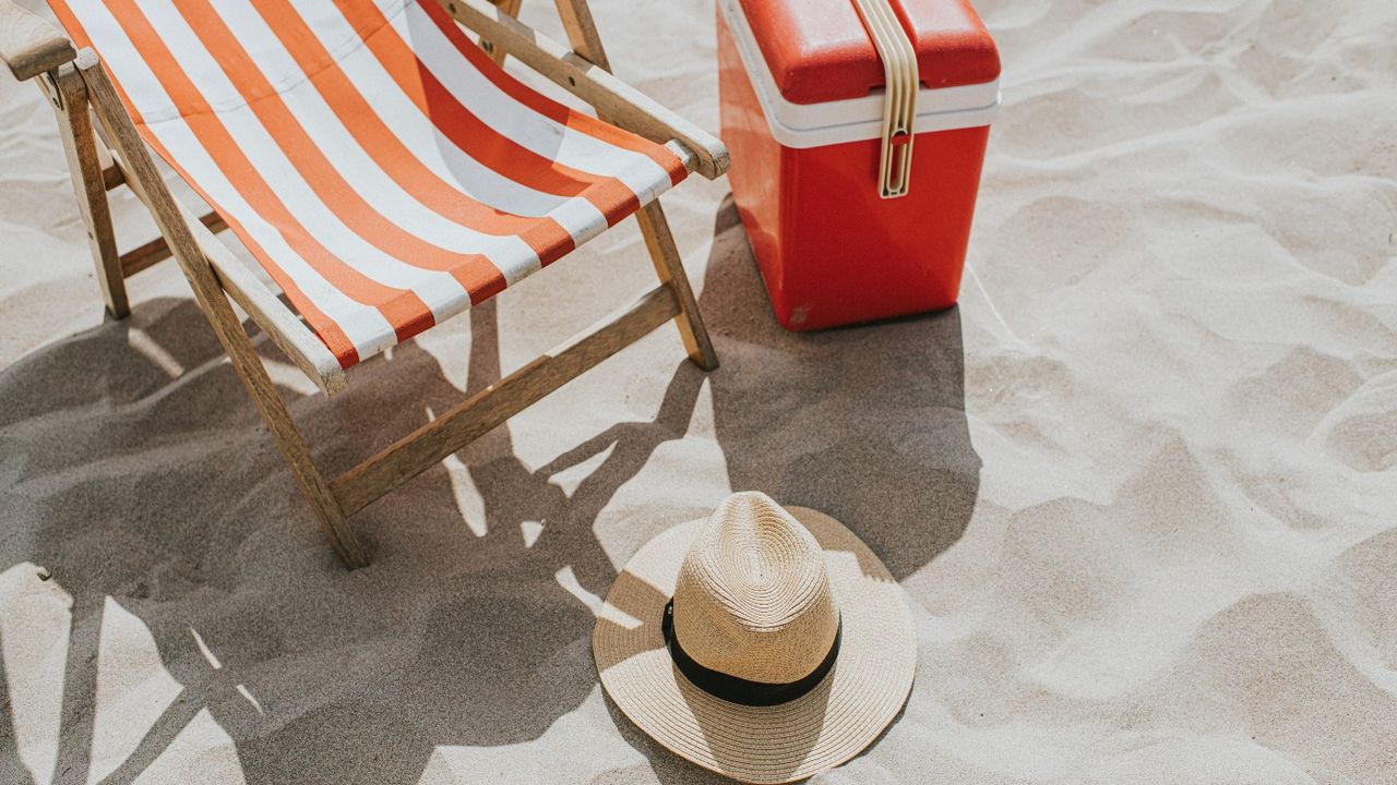 Deckchair on sand next to hamper