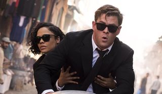 Tessa Thompson and Chris Hemsworth as Agent M and Agent H riding a hovercycle in Men In Black Intern