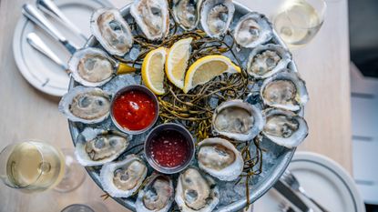 A plate of oysters served with slices of lemon
