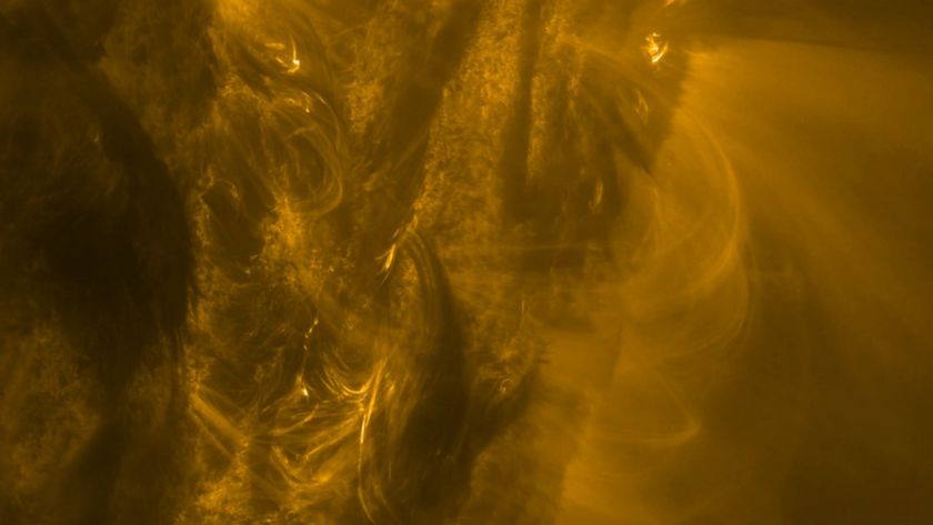 A close up of the sun showing golden light and energy spewing from its side