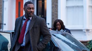 Idris Elba getting out of a car in Luther