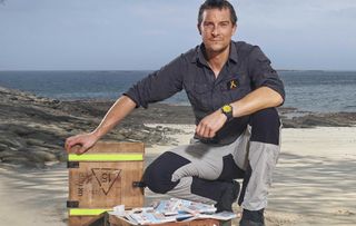 Bear Grylls with a box full of money