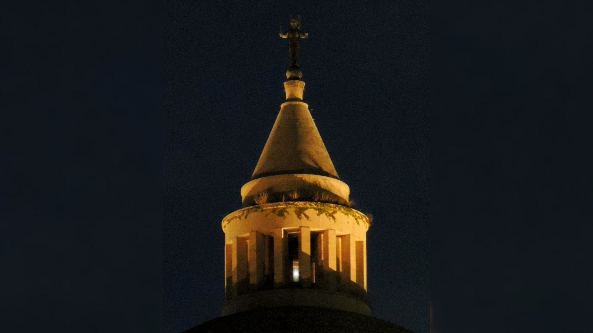 a bright light shines between columns of a domed building