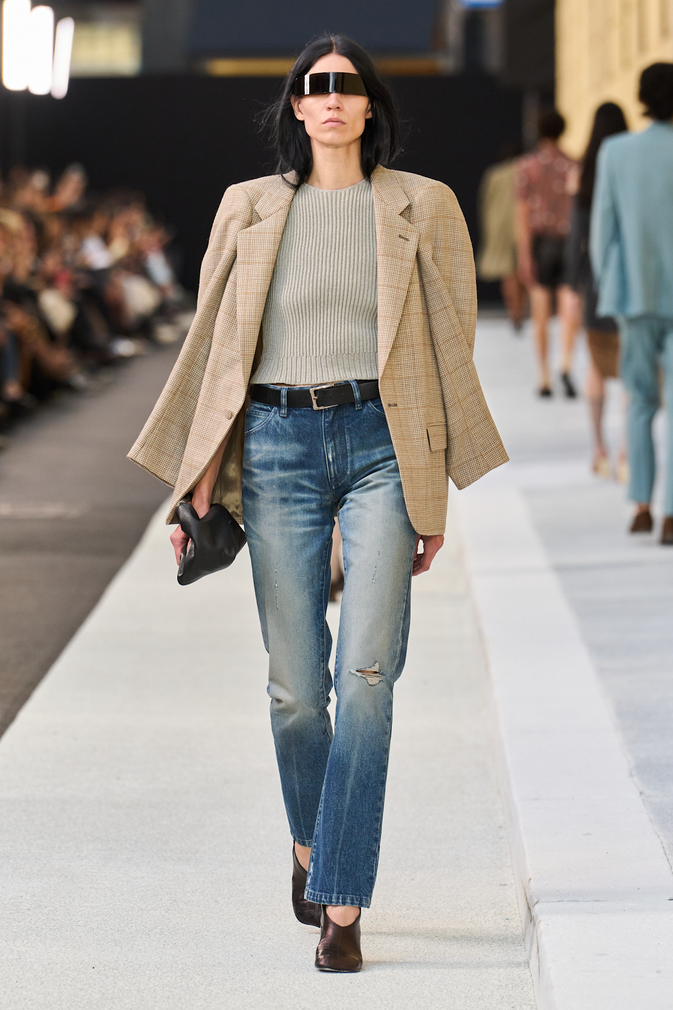 Margiela S/S 26 runway a model wears washed out jeans, tan blazer, beige shirt and black belt.