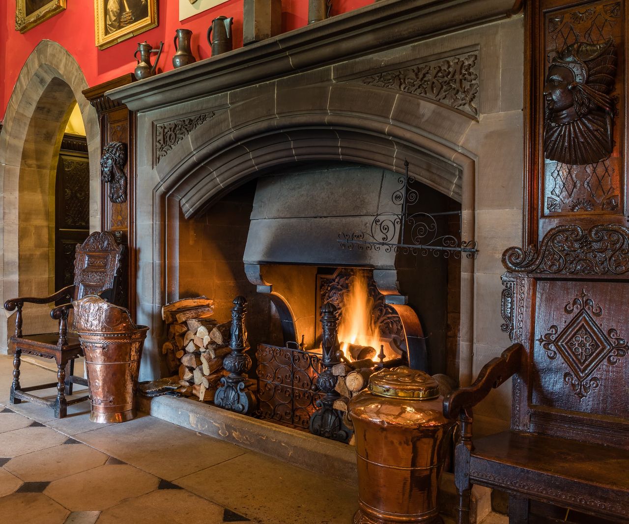 A large stone fireplace with logs stacked up next to it