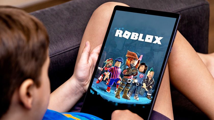 A boy playing Roblox on a table on the couch