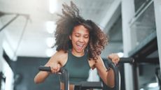 Shot of a young woman working out on an exercise bike in a gym