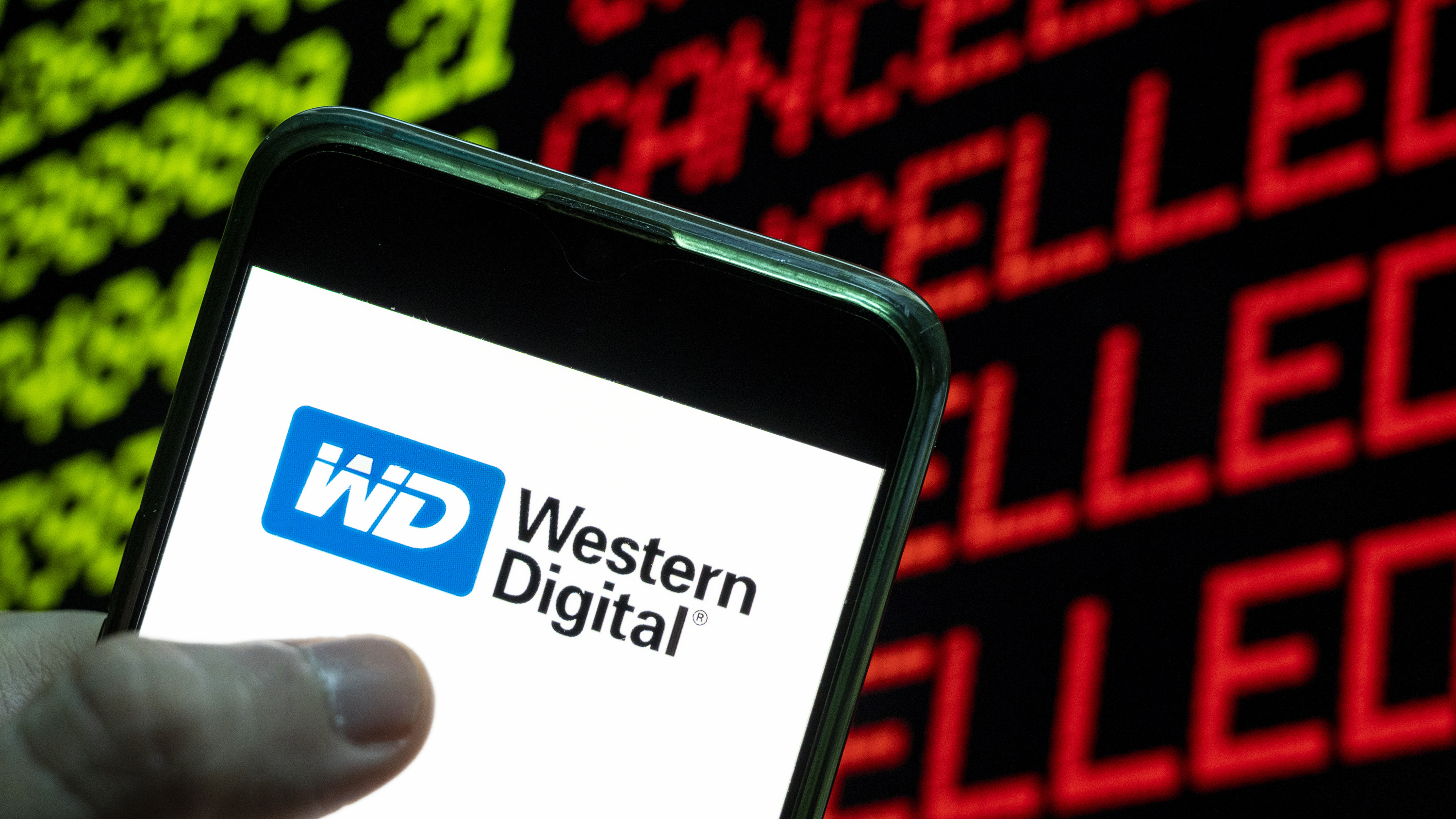 CHINA - 2021/04/24: In this photo illustration the American computer hard disk drive and data storage manufacturer Western Digital (WD) logo is seen on an Android mobile device with the word cancelled on a computer screen. (Photo Illustration by Budrul Chukrut/SOPA Images/LightRocket via Getty Images)