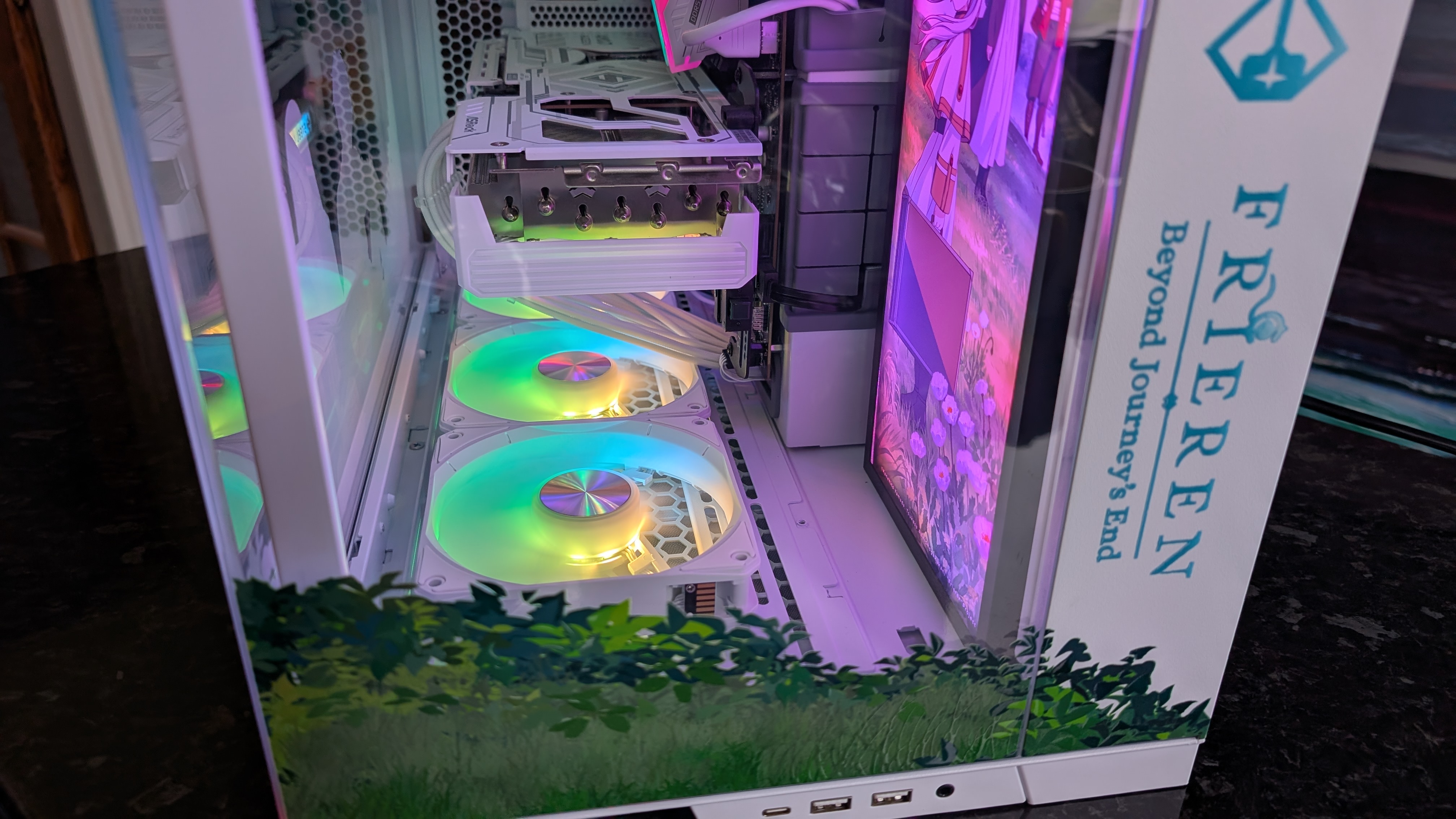 The Starforge Systems Frieren PC, photographed on a dark worktop with the RGB lighting switched on.