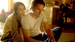 winona ryder and ethan hawke sitting on a bed together in reality bites