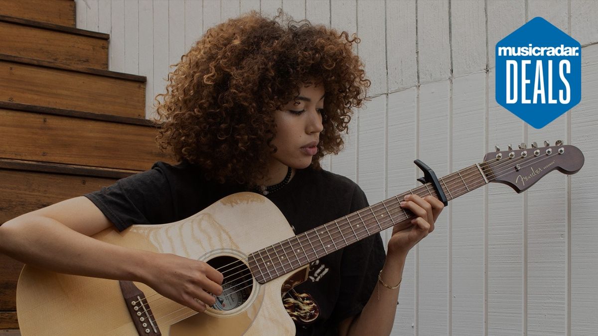 A woman plays acoustic guitar with a capo