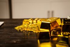 Gold bars and stacks of cash sit on a table