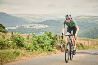 Female cyclist riding up a hill