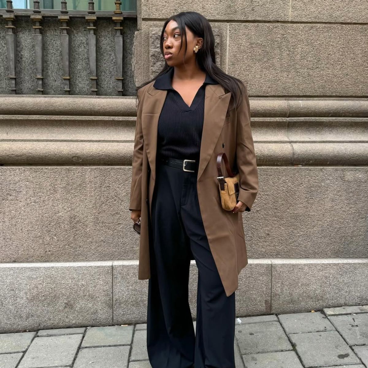 Influencer Nnenna Echem in black wide-leg pants and white sneakers. 