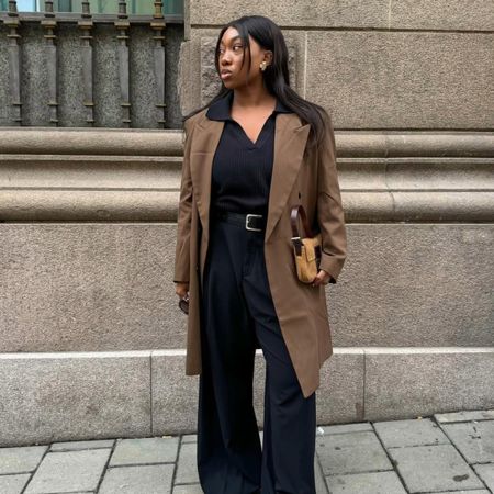 Influencer Nnenna Echem in black wide-leg pants and white sneakers. 