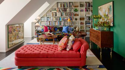 maximalist style scandinavian interiors with green wall, red bench seat, library wall, attic wall, exposed beam, colorful patterned sofa and colorful cushions
