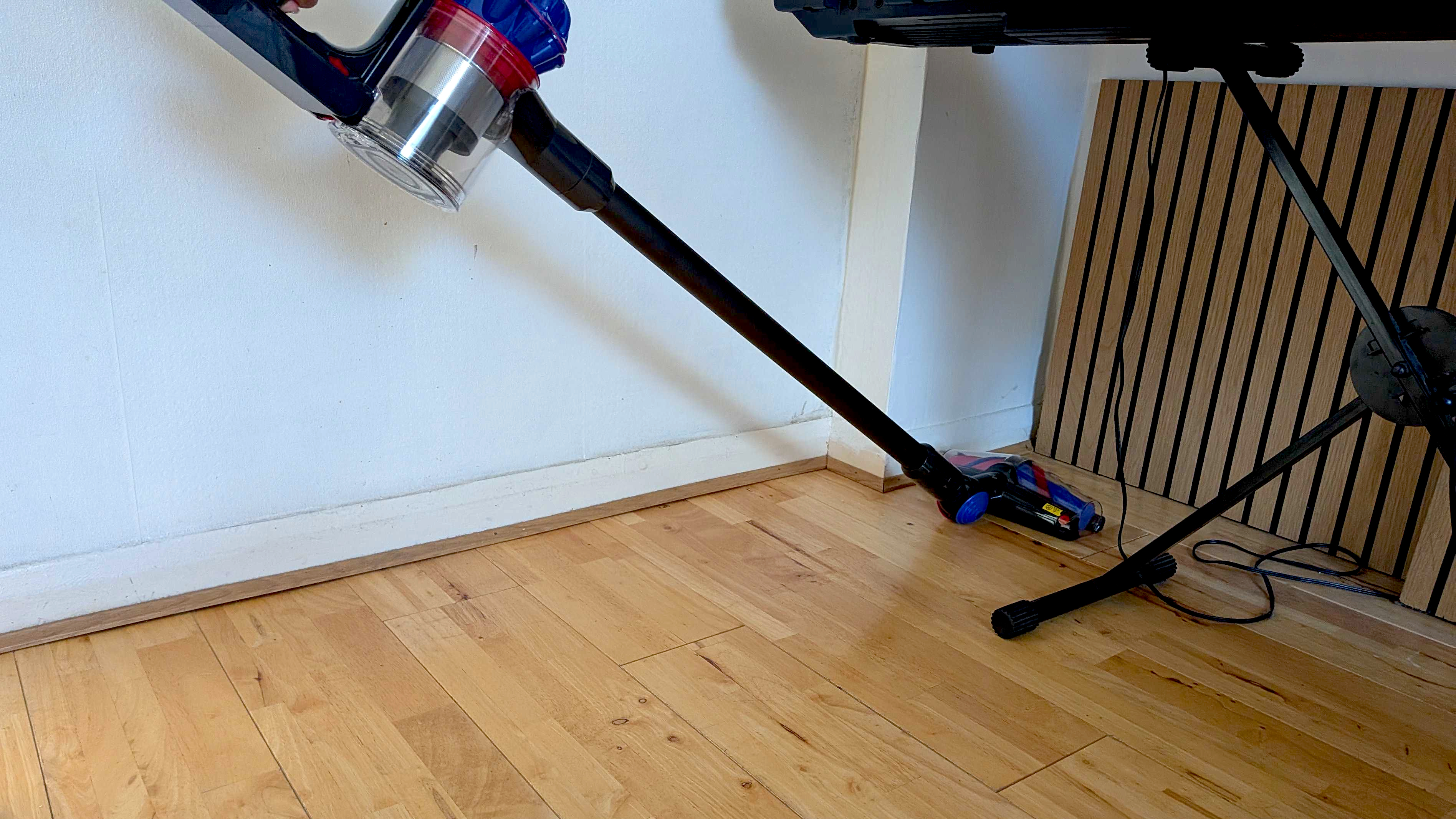 Vacuuming far corner of room