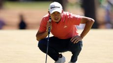 Collin Morikawa reads a putt at The Masters