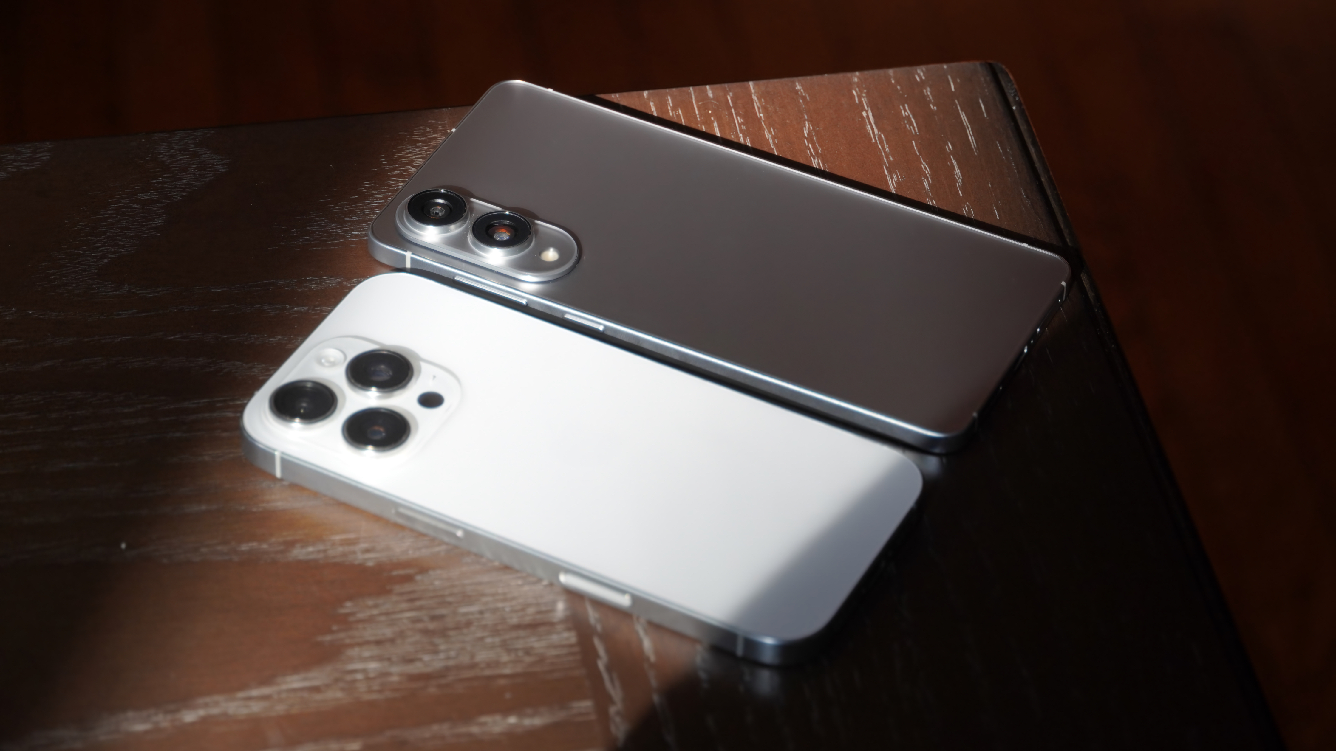 An iPhone 16 Pro with a telephoto lens beside a Samsung Galaxy S25 Edge without one.