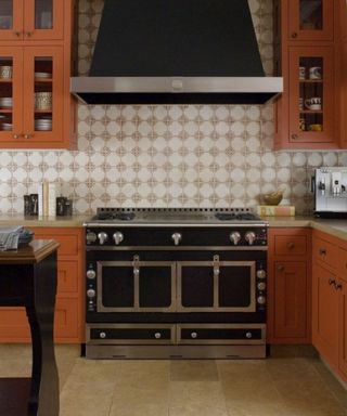 kitchen with orange cabinets and black oven
